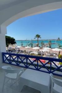 a balcony with a view of a beach with chairs and umbrellas at Porto marina in El Alamein