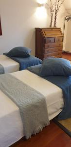 Duas camas num quarto com uma cómoda e um quarto em Alto Belo em Felgueiras