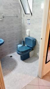 a bathroom with a blue toilet and a sink at Dardiza Stay in Ermioni