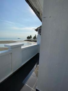 uma vista para a praia a partir da varanda de uma casa em PD Seaview Paradise Lagoon Apartment em Porto Dickson
