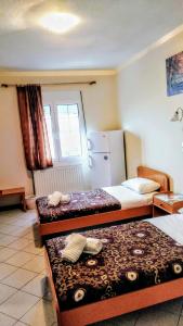 a hotel room with two beds and a refrigerator at Dardiza Stay in Ermioni