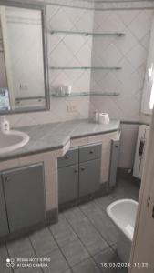 W łazience znajduje się umywalka, toaleta i lustro. w obiekcie Casa torvaianica w mieście Torvaianica