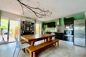 a kitchen with a wooden table and a bench at The family villa with indoor swimming pool air conditioning and wooded gar in Teyran