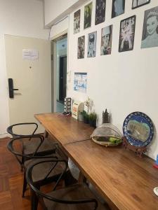 a wooden table with chairs and pictures on the wall at Hoi To Hostel in Hong Kong
