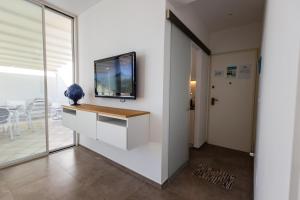 a living room with a tv on a wall at Attico Margherita - LA TERRAZZA SUL MARE in Gallipoli