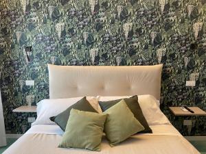 a bed with two pillows in a bedroom with a wallpaper at GiGa MaRe Apartments in Sorrento