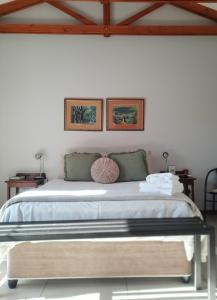 ein Schlafzimmer mit einem großen Bett mit zwei Bildern an der Wand in der Unterkunft Allegro Guest House in Prieska