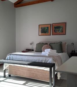 a bedroom with a large bed with two pictures on the wall at Allegro Guest House in Prieska