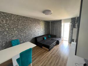 ein Wohnzimmer mit einem schwarzen Sofa und blauen Stühlen in der Unterkunft Apartament Queen in Oradea