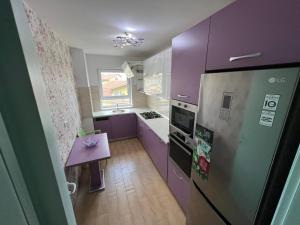 eine Küche mit lila Schränken und einem lila Kühlschrank in der Unterkunft Apartament Queen in Oradea