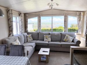 a living room with a couch and a large window at Stunning Caravan on Swanage Bay View Holiday Park in Swanage