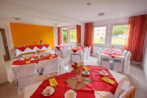 uma sala de jantar com mesas e cadeiras vermelhas e brancas em Hotel B1 em Berlim