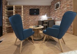 2 blaue Stühle in einem Zimmer mit einem Tisch in der Unterkunft L'Atelier Haute Couture in Le Mans