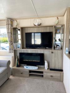 a living room with a large flat screen tv at Stunning Caravan on Swanage Bay View Holiday Park in Swanage