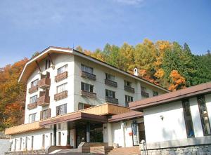 a large white building with balconies on top of it at Nozawa Grand Hotel in Nozawa Onsen