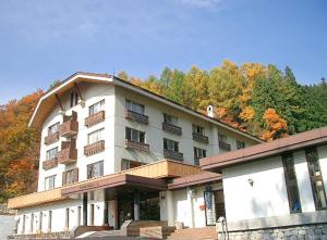 un gran edificio blanco con balcones en la parte superior. en Nozawa Grand Hotel en Nozawa Onsen