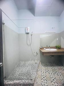 a bathroom with a shower with a sink and a mirror at Marieline Hotel Pham Ngu Lao in Ho Chi Minh City