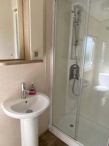 a bathroom with a sink and a shower at Stunning Caravan on Swanage Bay View Holiday Park in Swanage