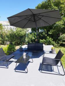 a patio with a table and chairs and an umbrella at Kaliva Residence in Kalamaki