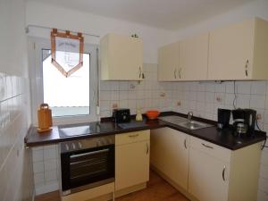 a small kitchen with white cabinets and a window at Wonderful Apartment in Elpe with Garden in Elpe