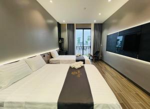 a hotel room with two beds and a flat screen tv at Olive SamSon Hotel in Sầm Sơn +53 photos