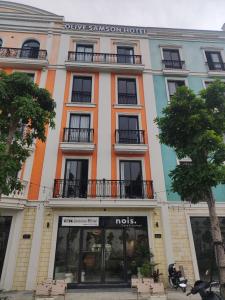 a building with a sign on the front of it at Olive SamSon Hotel in Sầm Sơn