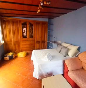 a bedroom with a white bed and a couch at El Chivero in Fuengirola