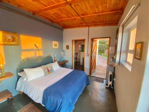 um quarto com uma cama num quarto com tectos em madeira em Agulhasbestview em Agulhas