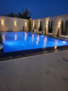a large swimming pool with blue water at night at La Seema sea view chalet in Madaba