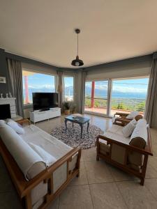 a bedroom with two beds and a large window at Up on the hill in Nafpaktos