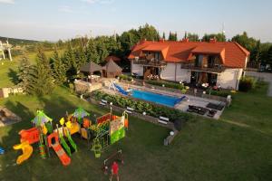 una vista aérea de una casa con piscina y parque infantil en Apartamenty Pod Łysicą & SPA - przy stoku, basen, jacuzzi, sauna, en Krajno Pierwsze