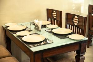 einen Tisch mit Tellern und Gläsern darüber in der Unterkunft PerfectStayz B2L Hills Tapovan in Rishikesh