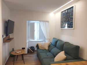 a living room with a green couch and a table at Casa Anton in Muxia