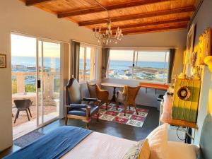 a bedroom with a bed and a desk with a view of the ocean at Agulhasbestview in Agulhas