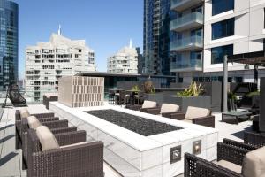 a rooftop patio with chairs and tables and buildings at Rincon Hill 1BR w AC Gym nr Bay Bridge SFO-156 in San Francisco