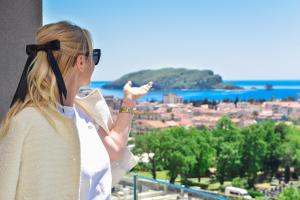 Una mujer parada en un balcón mirando una ciudad. en New Chill and Go Apartments, en Budva