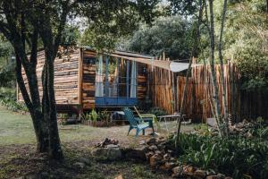 a log cabin with a bench and a tree at Firefly Falls in Plettenberg Bay