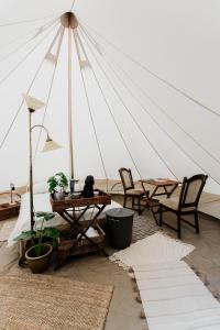 Tienda con mesas y sillas en una habitación en Luxe Glamping Tent in West-Friesland, en Venhuizen