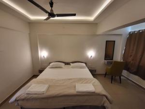 a bedroom with a large bed with a ceiling fan at Palm Crest The Colva Diaries in Colva