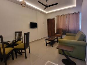 a living room with a couch and chairs and a table at Palm Crest The Colva Diaries in Colva