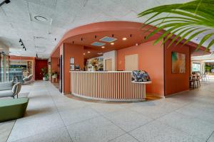 an office lobby with orange walls and a counter at Kyriad Marseille Palais Des Congr&egrave;s &ndash; V&eacute;lodrome in Marseille