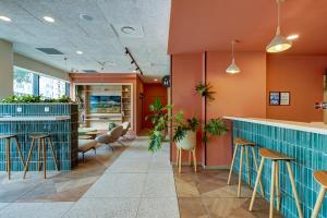 een bar in een restaurant met oranje muren en krukken bij Kyriad Marseille Palais Des Congrès – Vélodrome in Marseille