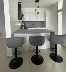 a kitchen with two bar stools and a counter at Green Coast 136 in Dhërmi