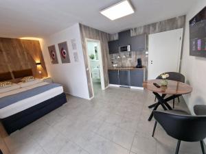 ein Schlafzimmer mit einem Bett und einem Tisch sowie eine Küche in der Unterkunft Sweet Retreat Apartment Lahr in Lahr