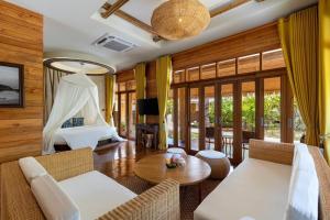 een woonkamer met een bed en een tafel bij Bulow Casa Grand View Resort in Ko Lipe