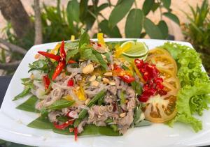 une assiette blanche avec salade et viande et légumes dans l'établissement Cheata Residence, à Siem Reap