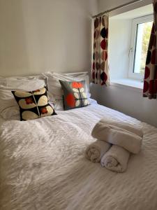 a bed with a pile of towels on it at Eviedale Cottages ltd in Evie +13 photos