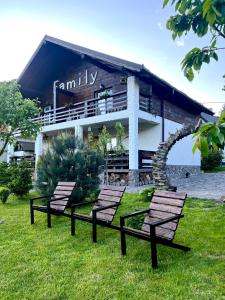 three benches in the grass in front of a building at Chalet "Family" in Suskovo