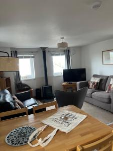 a living room with a table and a couch at Eviedale Cottages ltd in Evie