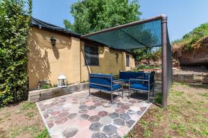 a patio with blue chairs and a gazebo at Luxury House in Green Appia Antica in Rome